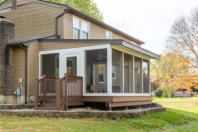 rear view of property with a yard and a sunroom