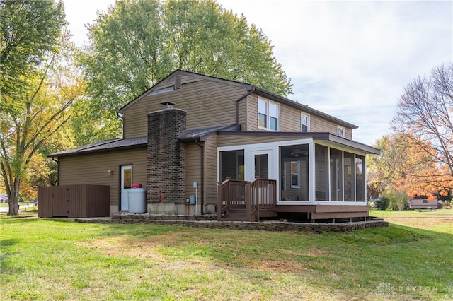 back of property featuring a lawn and a sunroom