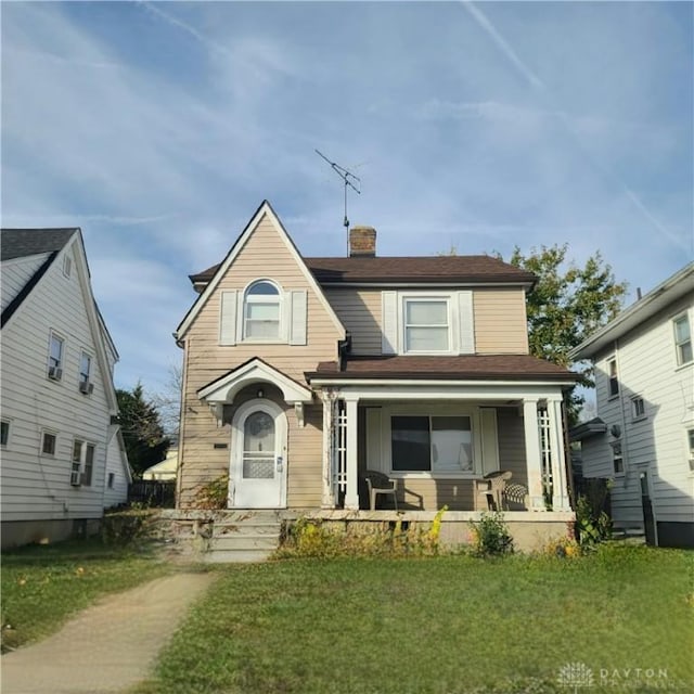 view of front of house featuring covered porch and a front lawn