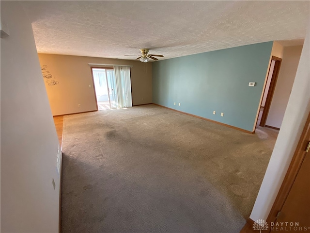 empty room featuring light carpet, a textured ceiling, and ceiling fan