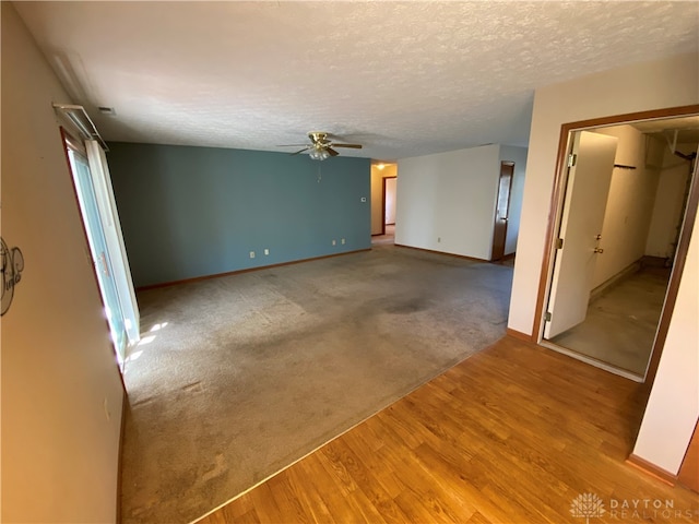 unfurnished room featuring a textured ceiling, wood-type flooring, and ceiling fan