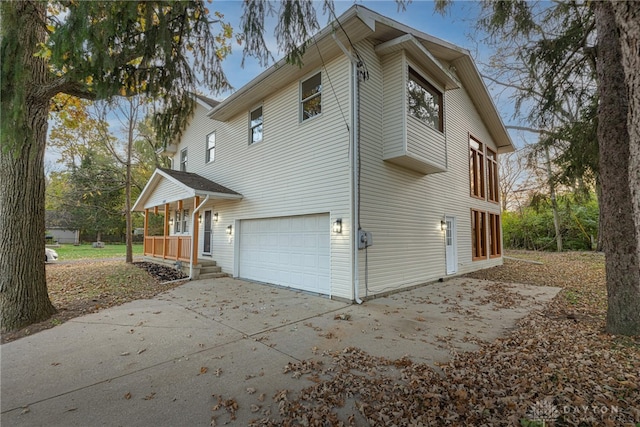 view of property exterior featuring covered porch and a garage