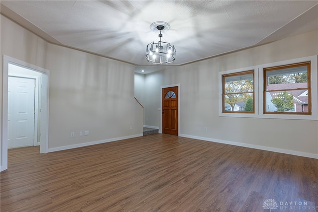 unfurnished room with dark hardwood / wood-style flooring and a chandelier