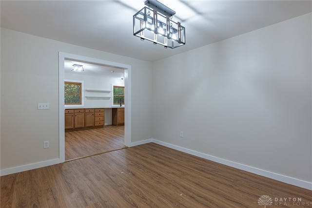 unfurnished dining area with hardwood / wood-style flooring and a notable chandelier