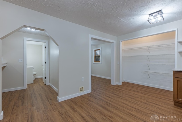 bonus room featuring dark wood-type flooring and a textured ceiling