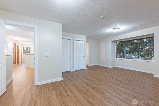 basement featuring hardwood / wood-style floors and a textured ceiling