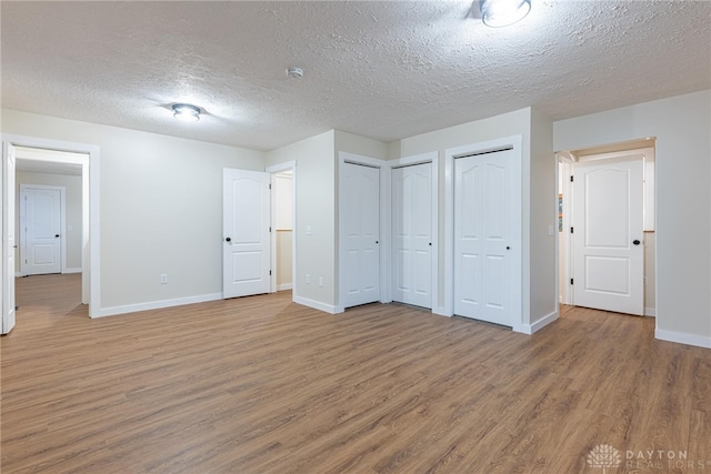 unfurnished bedroom with wood-type flooring and a textured ceiling