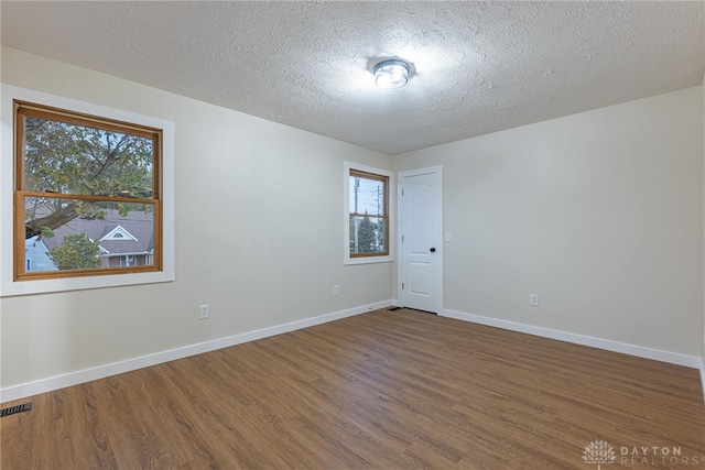 unfurnished room featuring a textured ceiling and hardwood / wood-style flooring