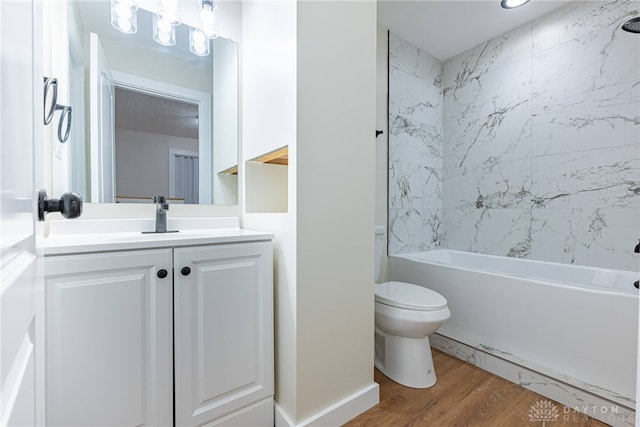 full bathroom with toilet, vanity, wood-type flooring, and tiled shower / bath combo