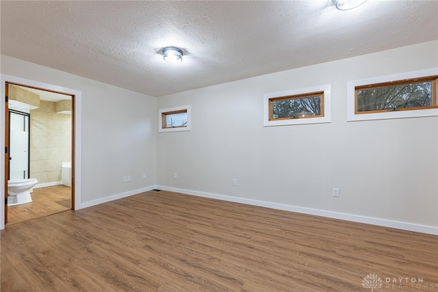 basement featuring a textured ceiling and hardwood / wood-style flooring