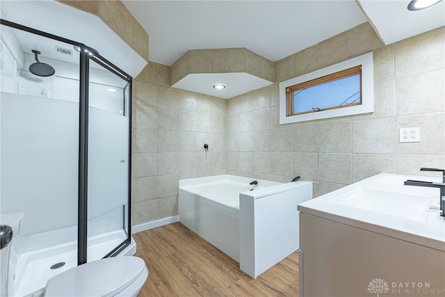 full bathroom featuring wood-type flooring, vanity, and tile walls