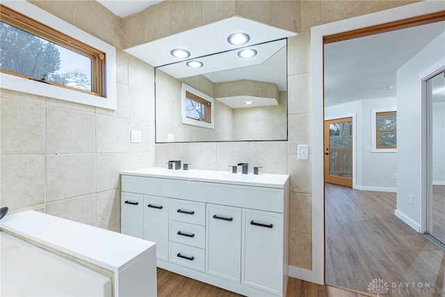 bathroom featuring tile walls, hardwood / wood-style flooring, and vanity