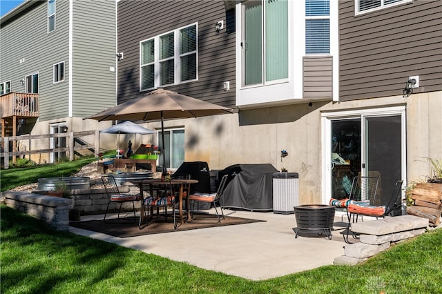 back of property with a patio and an outdoor fire pit