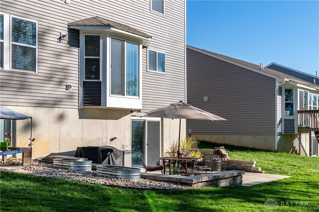 back of property with a patio and a lawn