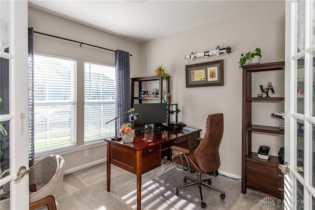 office area featuring a wealth of natural light, french doors, and light colored carpet