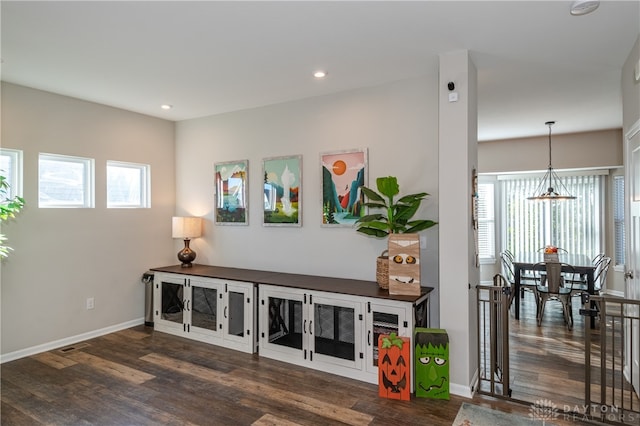 living room with dark wood-type flooring and a notable chandelier