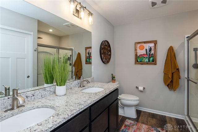 bathroom with a shower with door, hardwood / wood-style flooring, vanity, and toilet