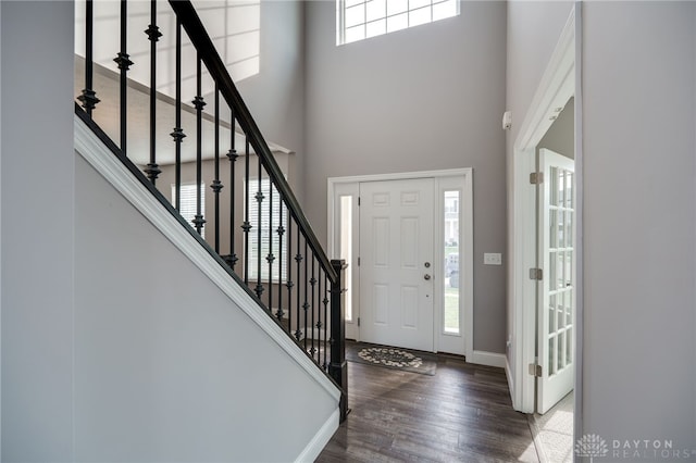 entryway with a towering ceiling and dark hardwood / wood-style flooring