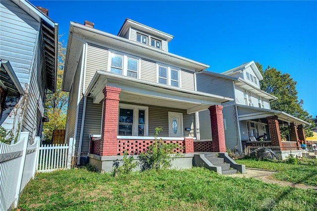 view of front of home with a front yard and covered porch