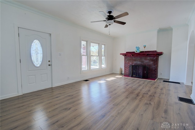 unfurnished living room featuring crown molding, a fireplace, and hardwood / wood-style flooring