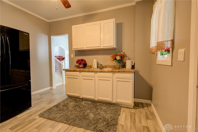 kitchen featuring white cabinets, light hardwood / wood-style flooring, sink, and black refrigerator