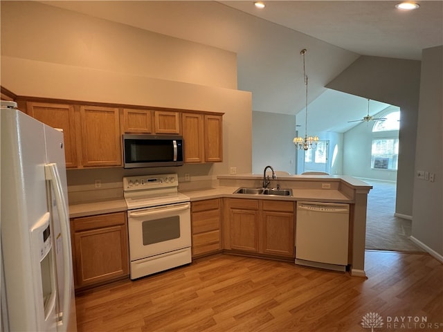 kitchen featuring hanging light fixtures, sink, vaulted ceiling, white appliances, and ceiling fan with notable chandelier