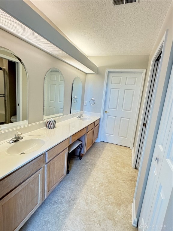 bathroom with vanity and a textured ceiling