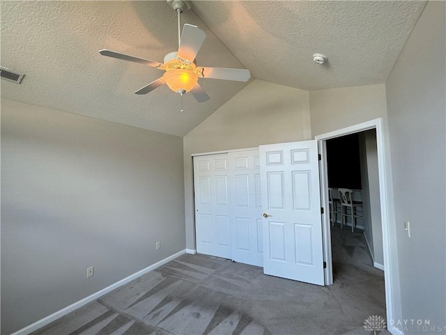 unfurnished bedroom with visible vents, baseboards, vaulted ceiling, carpet flooring, and a closet