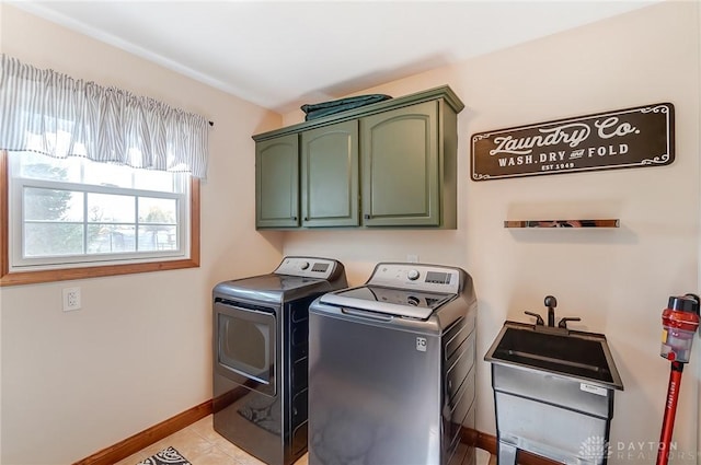 laundry room with cabinets, light tile patterned floors, sink, and washing machine and clothes dryer