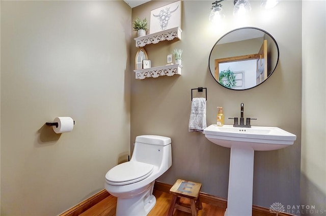 bathroom with hardwood / wood-style flooring and toilet