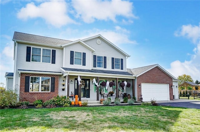 view of front of house with covered porch, a garage, and a front lawn