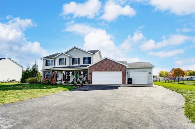 view of front of house featuring a garage, covered porch, and a front lawn