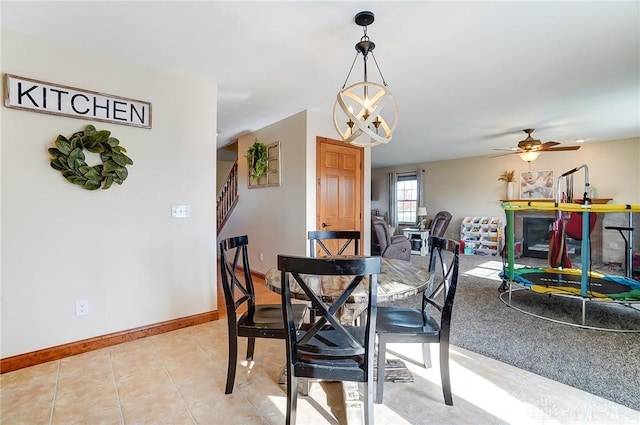 dining area with ceiling fan with notable chandelier and light tile patterned floors