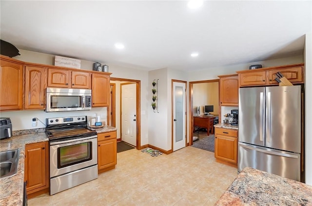 kitchen with sink, light stone countertops, and stainless steel appliances