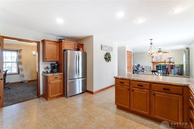 kitchen with stainless steel refrigerator, ceiling fan, hanging light fixtures, and light carpet