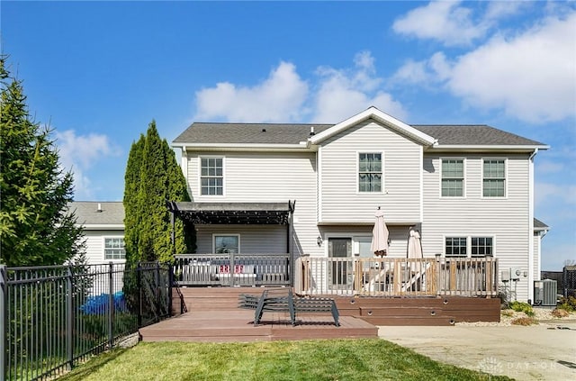 rear view of house featuring a lawn, a wooden deck, and central AC unit