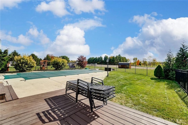 deck with a covered pool, a patio area, and a lawn