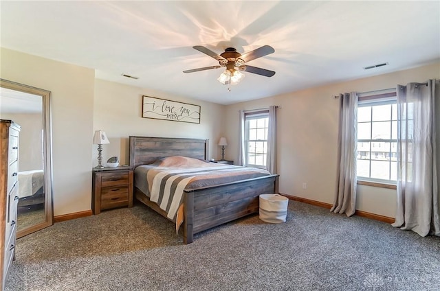 carpeted bedroom featuring multiple windows and ceiling fan