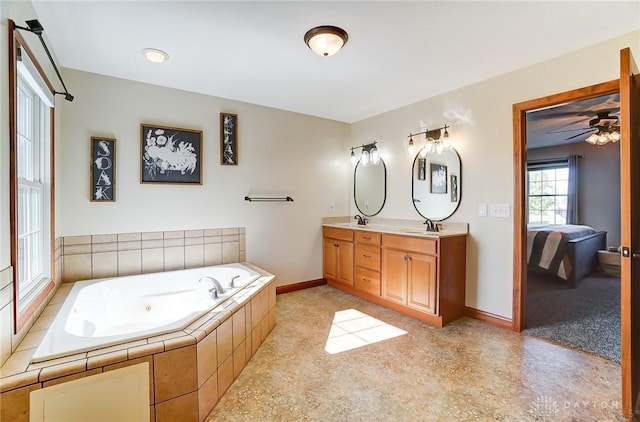 bathroom featuring vanity, ceiling fan, and tiled bath