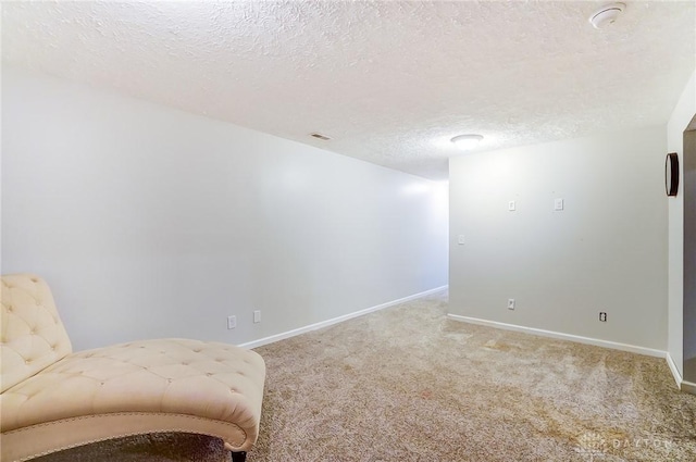 unfurnished room with carpet flooring and a textured ceiling