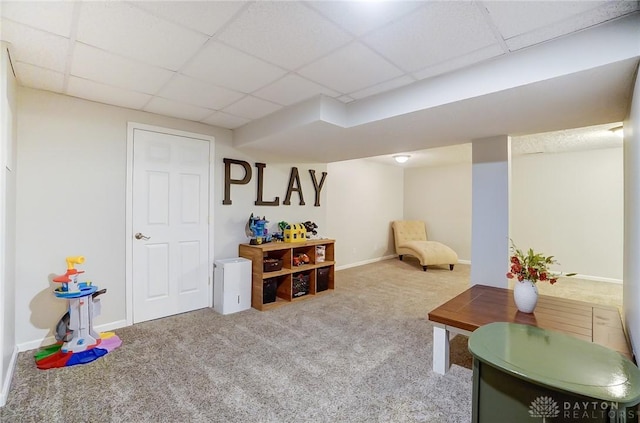 interior space featuring a paneled ceiling and carpet floors