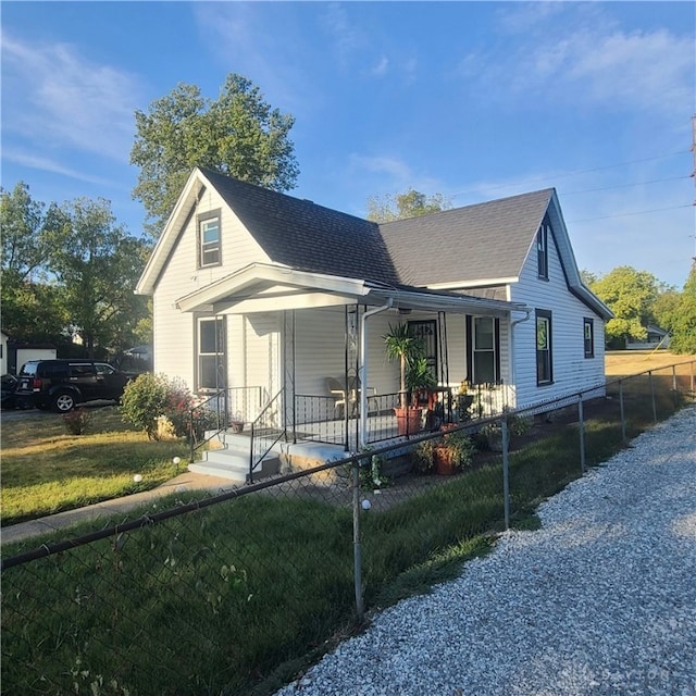 bungalow with a porch and a front lawn