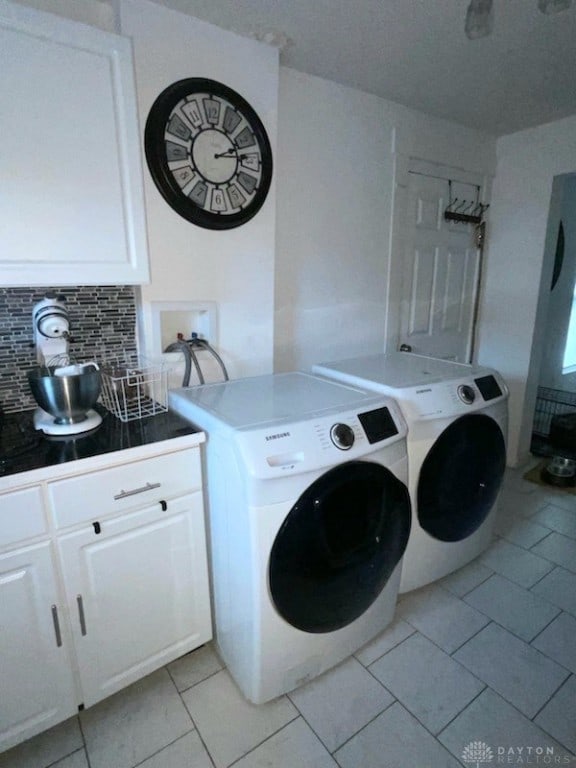 washroom featuring washer and clothes dryer and light tile patterned floors