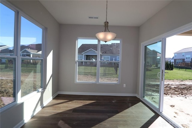 dining room with plenty of natural light and dark hardwood / wood-style floors