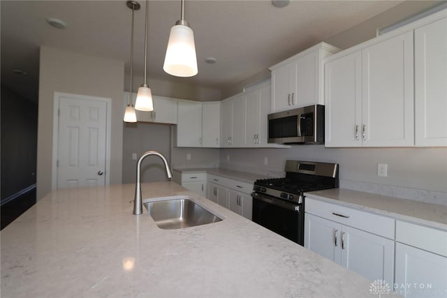 kitchen with white cabinets, light stone counters, sink, and appliances with stainless steel finishes