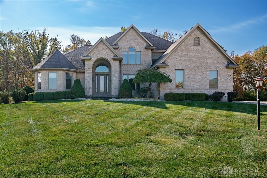 french country style house with a front lawn