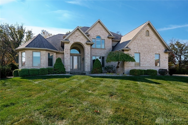 french provincial home with a front yard