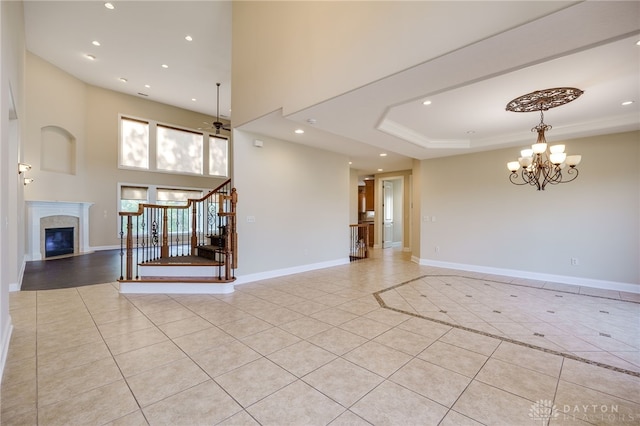 interior space featuring light tile patterned flooring and ceiling fan with notable chandelier