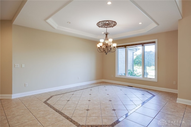 tiled empty room with an inviting chandelier and a raised ceiling