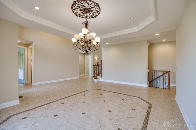 empty room featuring crown molding, a tray ceiling, an inviting chandelier, and light tile patterned floors